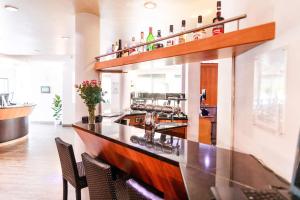 a kitchen with a bar and a table with drinks on it at Best Western Plaza Hotel Stuttgart-Filderstadt in Filderstadt