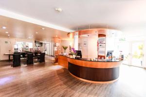 um lobby com um bar no meio de uma sala em Best Western Plaza Hotel Stuttgart-Filderstadt em Filderstadt