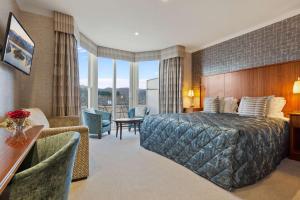a hotel room with a bed and a desk and chairs at Ambleside Salutation Hotel & Spa, World Hotel Distinctive in Ambleside