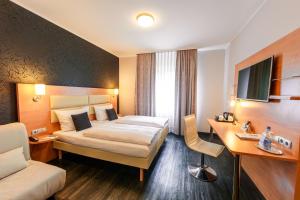 a hotel room with two beds and two lamps at Best Western Plaza Hotel Stuttgart-Filderstadt in Filderstadt