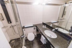a bathroom with a sink, toilet and mirror at Best Western Plaza Hotel Stuttgart-Filderstadt in Filderstadt