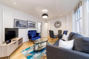 a living room with a couch and a tv at Garrick Mansions by Q Apartments in London