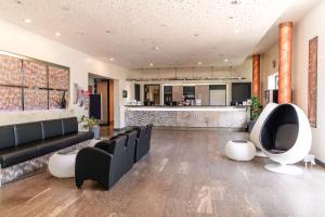 a lobby with a couch and chairs and a bar at Best Western Plaza Hotel Stuttgart-Ditzingen in Ditzingen