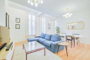 a living room with a blue couch and a table at Le Magnifique de Barrès in Nancy
