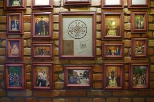 a wall of pictures on a brick wall at Hotel Tunnel of Love in Klevanʼ