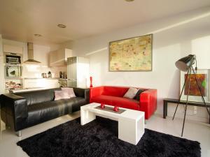 a living room with a red couch and a white table at Meerblick-Apartment Ula in Los Realejos