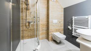 a bathroom with a shower and a toilet and a sink at Port Bogaczewo Hotel & SPA in Giżycko