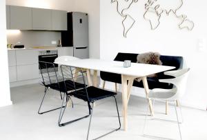 einen weißen Tisch und Stühle in der Küche in der Unterkunft Sommerloft Norderney Ferienhaus in Norderney