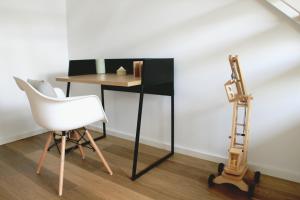 einen Schreibtisch in einem Zimmer mit einem Stuhl und einer Leiter in der Unterkunft Sommerloft Norderney Ferienhaus in Norderney