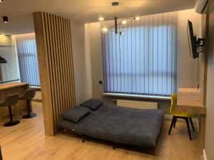 a bedroom with a bed and a desk and windows at Apartment near the airport in Boryspil