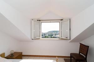 a white room with a window and a chair at Guest House Misita in Dubrovnik
