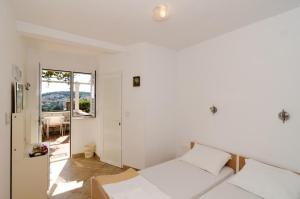 a white room with a bed and a window at Guest House Misita in Dubrovnik