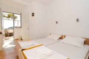 two white beds in a room with a window at Guest House Misita in Dubrovnik