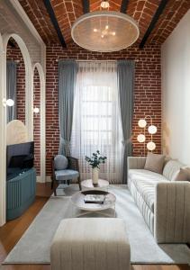 a living room with a couch and a brick wall at Ecole St. Pierre Hotel in Istanbul