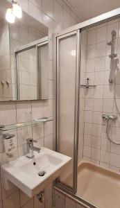 a white bathroom with a sink and a shower at Hotel Prox in Arnstadt