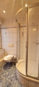 a bathroom with a tub and a toilet and a shower at Hotel Prox in Arnstadt