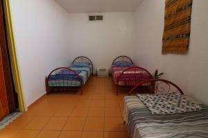 a room with three beds in a room at Ait Mouli Surf House in Safi