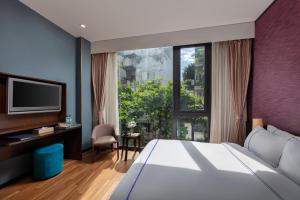 
a hotel room with a tv and a bed at Oriana Boutique Hotel & Spa in Hanoi
