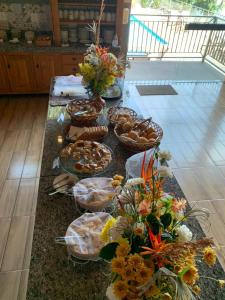 uma mesa com muitas cestas de comida e flores sobre ela em Pousada Mar de Minas em Capitólio