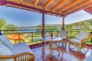balcón con mesa, sillas y vistas al océano en Villa Laguna, en Vourvourou