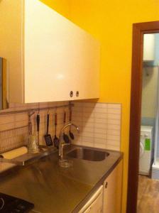 uma cozinha com um lavatório e uma parede amarela em Roma Cinecittà em Roma
