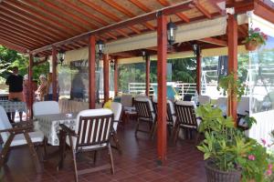 a patio with white chairs and tables and a wooden roof at Villa D&L in Ohrid