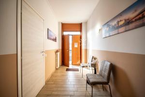 a hallway with a chair and a table and a door at MILAN BERGAMO HOUSE - MBH in Cologno al Serio