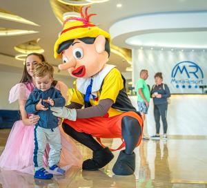 młode dziecko i osoba ubrana w kostiumy myszki Mickey w obiekcie Mera Resort w mieście Venus