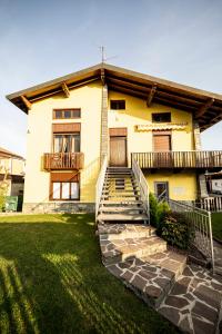 a yellow house with stairs in front of it at MILAN BERGAMO HOUSE - MBH in Cologno al Serio