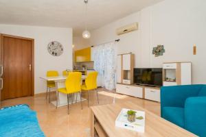 a living room with a table and yellow chairs at Apartment Angie - terrace with sea view in Nečujam