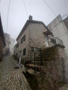 una antigua casa de piedra en una calle adoquinada en Casa da Serra - Serra da Estrela en Seia
