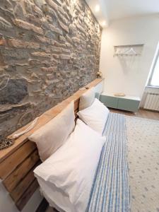 a bed in a room with a stone wall at Affittacamere Albarola in Riomaggiore