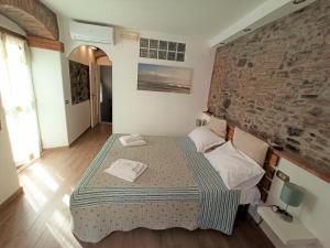 a bedroom with a bed and a brick wall at Affittacamere Albarola in Riomaggiore