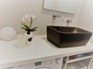 a kitchen counter with a sink and a vase of flowers at Maison 53 Incantevole appartamento vista Cattedrale di Como in Como
