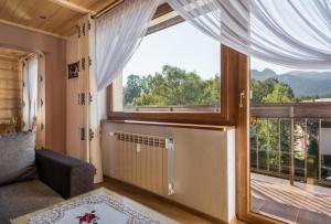 a living room with a large window and a couch at ApartHost Tatra Panorama in Zakopane