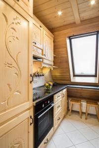 uma cozinha com armários de madeira, um fogão e uma janela em ApartHost Tatra Panorama em Zakopane