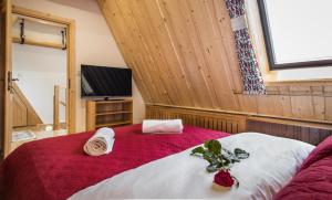 a bedroom with a red and white bed and a tv at ApartHost Tatra Panorama in Zakopane