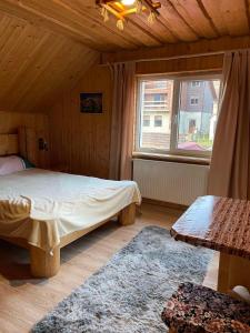 a bedroom with a bed and a large window at Sadyba Sunny House in Pilipets