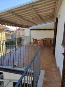 a patio with awning and tables and chairs on it at Verande in Sampieri