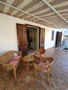 a patio with chairs and tables on a tile floor at Verande in Sampieri