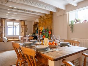 a dining room with a wooden table and chairs at Lark Rise Cottage in Blockley