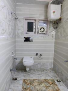 Baño blanco con aseo y lavamanos en Wintry homes 5 Bhk Villa, en Shimla