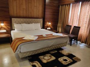 a hotel room with a bed and a chair at Red Carpet in Port Blair