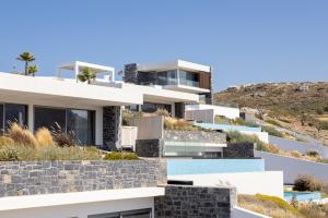 a house on a hill with white at Rock Bay Villas - Luxury Villas in Crete in Agia Pelagia