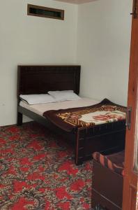a bed in a room with a red carpet at Welcome Guest House in Barāniā