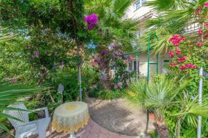 a garden with a table and chairs and flowers at Ferienwohnung in Okrug Gornji mit Meerblick, Terrasse, Klimaanlage, W-LAN 5046-3 in Novi Zagreb