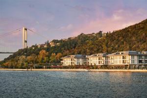 a group of houses on the water with a bridge in the background at Mandarin Oriental Bosphorus, Istanbul in Istanbul