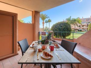 una mesa de madera con comida en el balcón en SIESTA BEACH 1, CON PLAYA y PARKING, en La Cala de Mijas