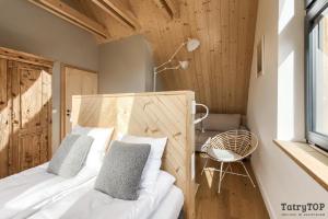 sypialnia z łóżkiem, krzesłem i oknem w obiekcie Czarne Wierchy jacuzzi - Luxury Chalets Kościelisko w mieście Kościelisko