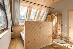 Pokój z drewnianymi drzwiami i krzesłem w obiekcie Czarne Wierchy jacuzzi - Luxury Chalets Kościelisko w mieście Kościelisko